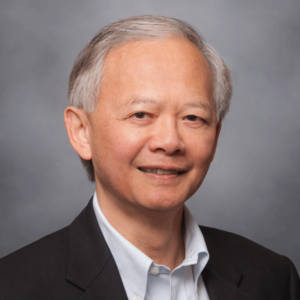 Headshot image of Director Dennis Lum, an Asian-American man with short graying hair wearing a dark jacket over a light collared shirt.