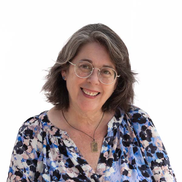 Headshot of Beth Suess, a white woman with shoulder-length graying dark hair and glasses.