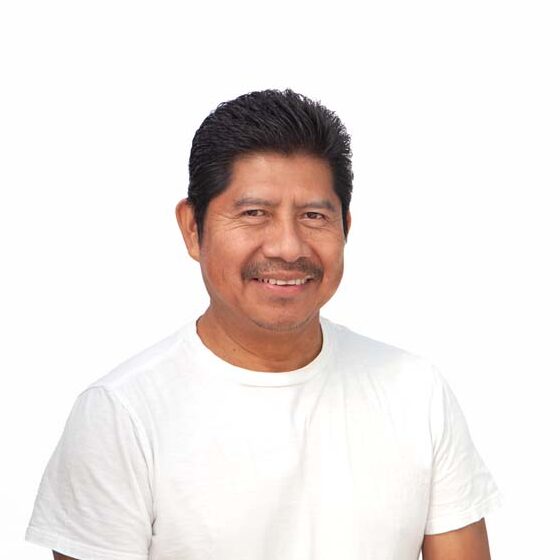Profile image of Melecio Cox, a Latino man with brown skin and black hair wearing a white t-shirt.