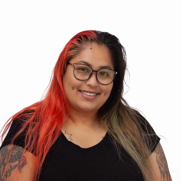 Profile image of Stephanie Soto, a Latina woman with light brown skin and long straight brown hair died bright red on one side.