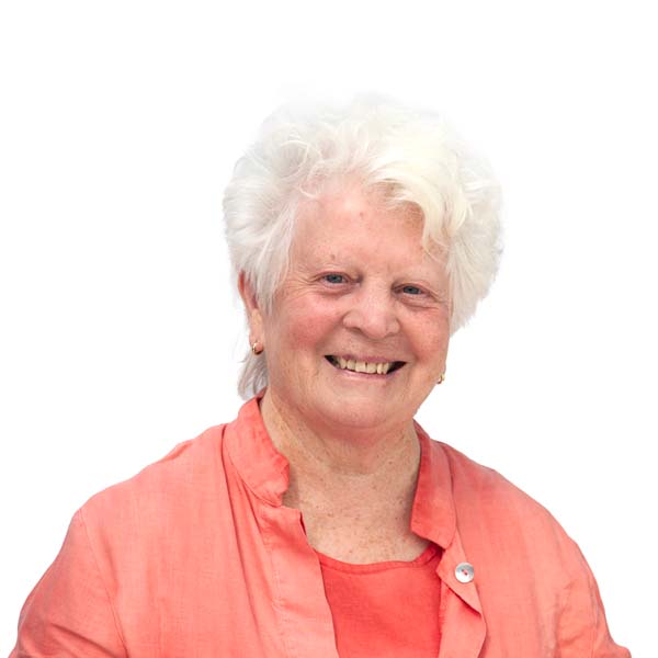 Profile image of Maureen Berndt, a White woman with a short bouffant of white hair wearing shades of coral pink.