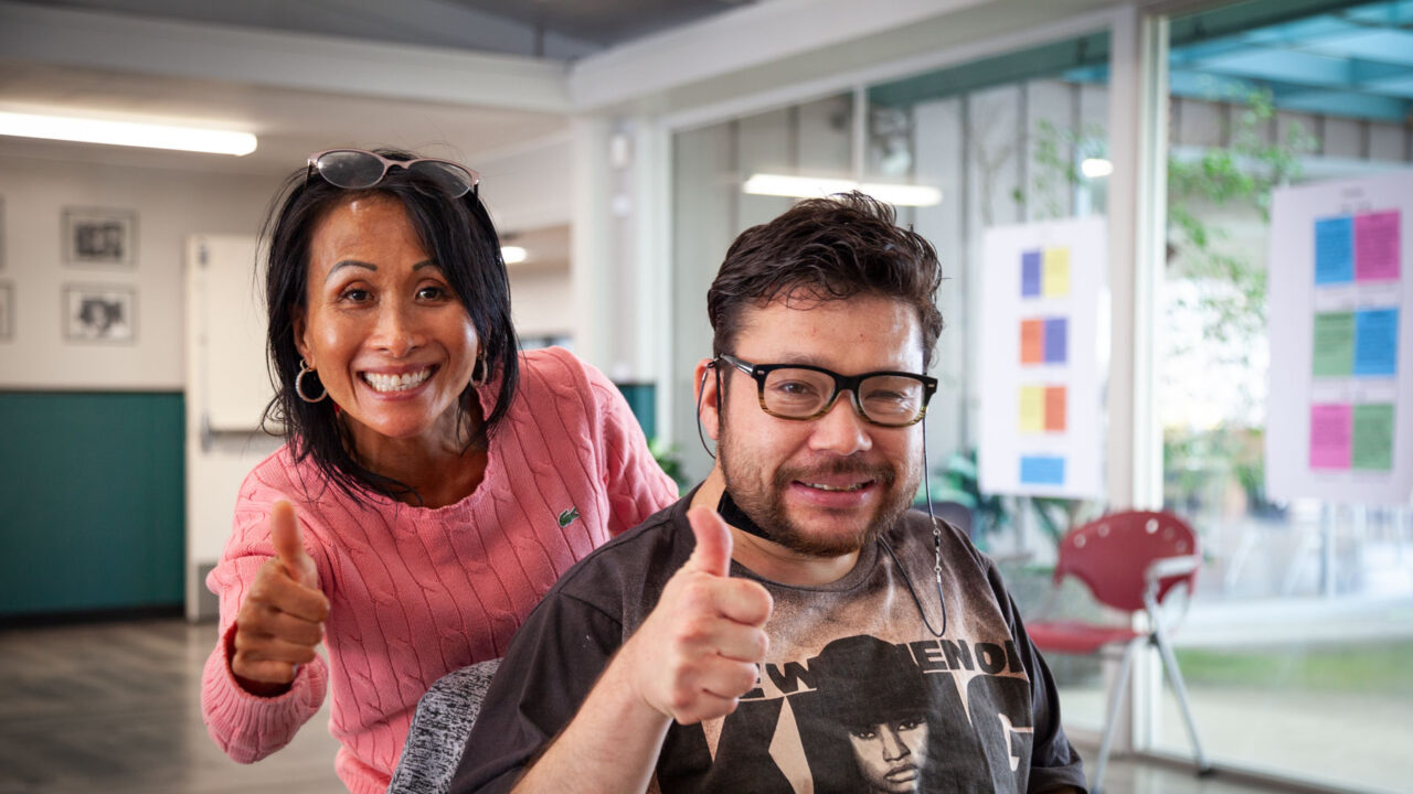 A participant and staff member of Ability Now offer a thumbs up